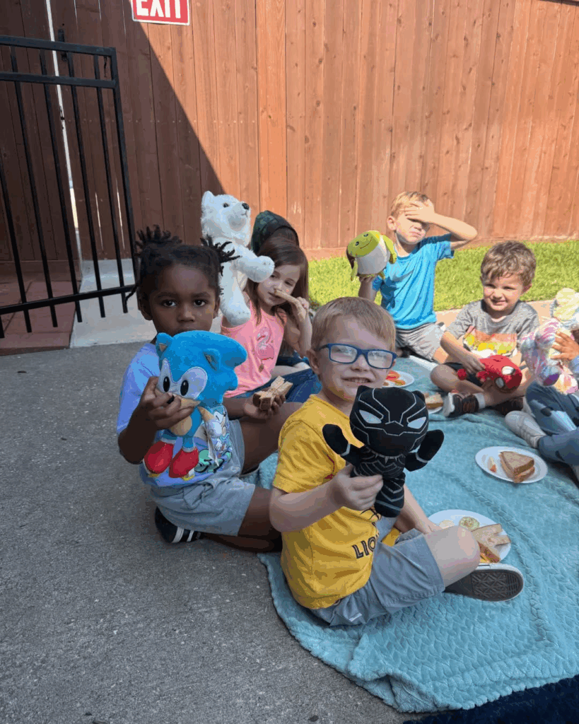 Preschoolers at Tiny People University Childcare Center in Magnolia, TX enjoying a picnic outside.