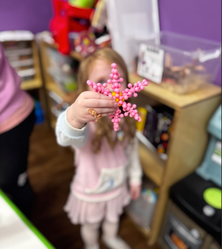 Child in a preschool program at Tiny People University Childcare Center in Magnolia, TX completing a hands-on learning activity. 